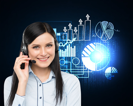Close up of woman with headset standing near blackboard with glowing graphs. Concept of call center....