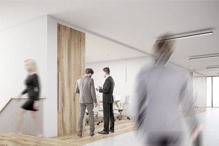 Rear view of man entering an office with people swarming in the lobby. Concept of busy workplace. 3d renderingの写真素材
