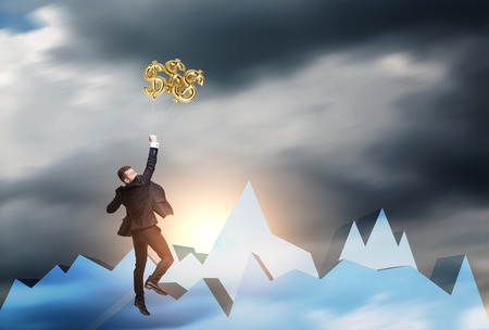 Rear view of a businessman jumping to reach dollar signs floating in the air. Concept of trading. Mock up. Toned image.の写真素材