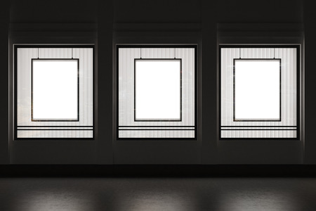 Shop window with three vertical framed posters in it. Black wall. Concept of advertising and goods...