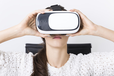 Close up of a woman with long brown hair wearing a virtual reality glasses. Concept of a cutting...
