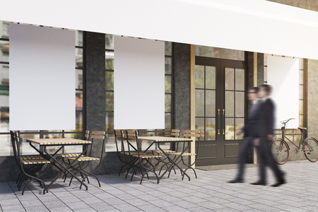 Side view of two men entering a cafe with posters on the windows and wooden tables and chairs. 3d rendering. Mock up.の写真素材