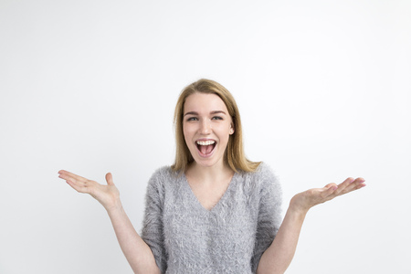 Happy blond woman with her palms in the air is really excited. Her mouth is open. She is laughing....