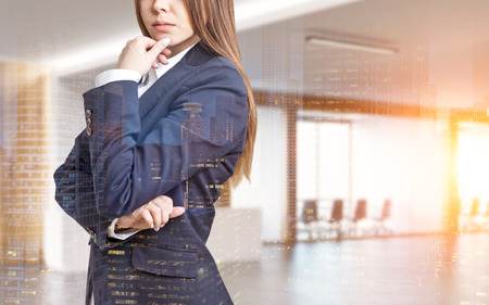 Close up of a businesswoman in a suit. She is standing in an office with conference room and thinking with her fingers on the chin. 3d rendering. Mock up. Toned image. Double exposureの写真素材