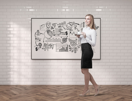 Side view of a blond woman with long hair holding her cup of coffee and standing near a whiteboard with a project sketch on it. 3d rendering. Mock upの写真素材