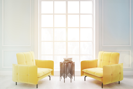 Two ellow armchairs and a coffee table are standing in a living room with a tall window. 3d rendering. Toned imageの写真素材