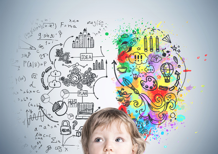 Close up of an adorable little baby boy s head against a gray wall with a creative idea sketch drawn on it.の写真素材