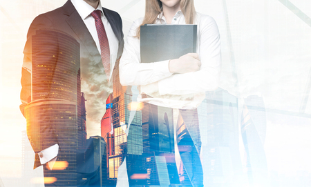 Two unrecognizable business partners are standing together against a foggy city panorama. Toned image, double exposureの写真素材