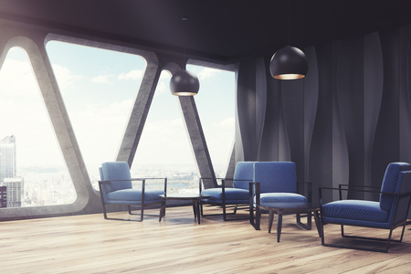 Modern office waiting area with black walls with wave pattern on them and blue armchairs near round...