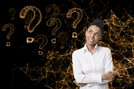 Portrait of a smiling African American woman standing with crossed arms against an orange virtual reality background. Question marks and abstract lines. Mock upの写真素材