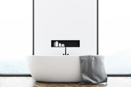 Close up of a white modern bathroom interior with a white tub standing near a window, a large towel hanging on its side and a shelf with cleaning products in the wall. 3d rendering, mock upの写真素材