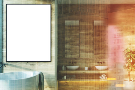 Wooden bathroom interior with a white tub, a vertical framed poster hanging above it, double sinks...