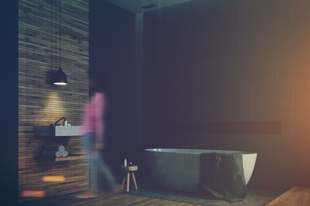 Black and wooden bathroom interior with a wooden floor, tall windows, a round white tub and an angular sink. Side view, a woman 3d rendering mock up toned image double exposureの写真素材