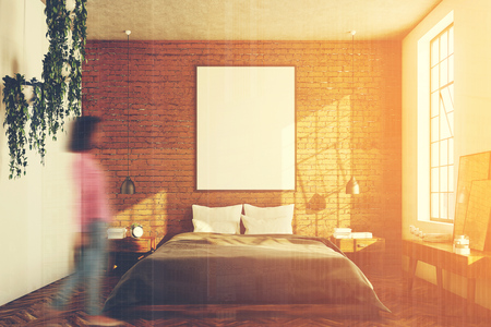 Brick bedroom interior with a wooden floor, a large window, a gray bed and two bedside tables. A cabinet with mirrors. A woman. 3d rendering mock up toned imageの写真素材