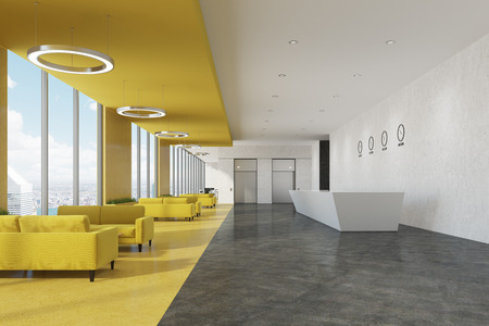 Side view of a white reception counter standing in an office with white and yellow walls and rows of...
