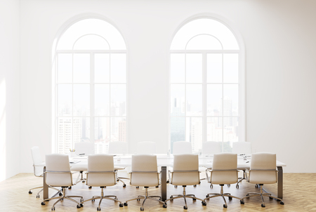Loft meeting room interior with white walls, a concrete floor, two long white tables with laptops on them. A front view. 3d rendering mock upの写真素材