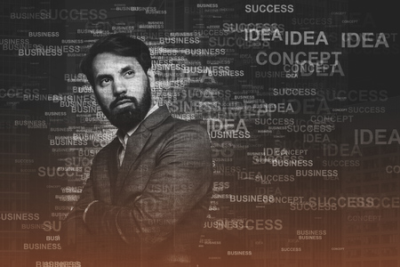 Serious bearded businessman standing with crossed arms near a gray wall with business words on it. 3d rendering mock up toned image double exposureの写真素材