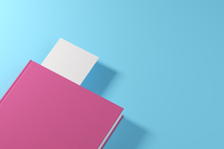 Closed pink book with a white bookmark is lying on a blue surface. Concept of advertising. 3d rendering mock upの写真素材