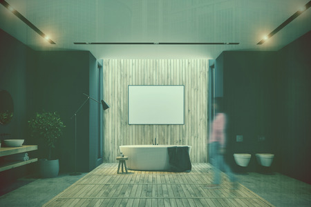 Woman in a black and wooden bathroom interior with a wooden floor, an oval tub, a double sink, a large poster and two toilets. 3d rendering mock up double exposure toned imageの写真素材