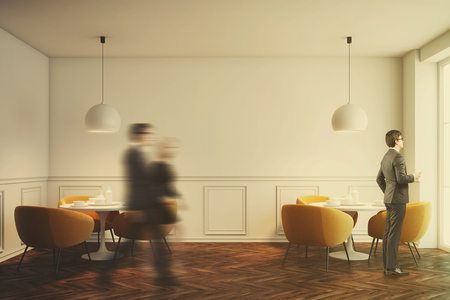 White cafe interior with a wooden floor, white round tables and soft orange chairs near them. Front view. People. 3d rendering mock up toned imageの写真素材