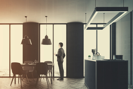 Kitchen interior with a wooden floor and gray countertops. A round table with chairs in the foreground. Side view, a businessman. 3d rendering mock up double exposure toned imageの写真素材
