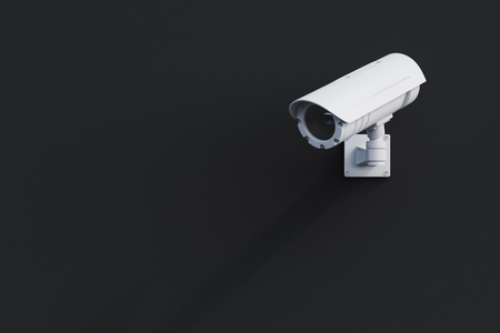 White CCTV camera attached to a blank black wall outside. Concept of security and surveillance. 3d rendering mock upの写真素材