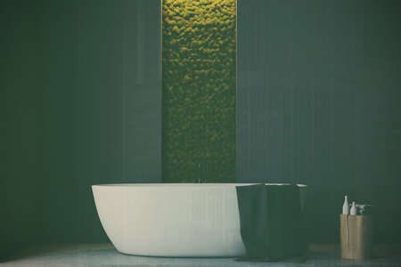 Gray bathroom interior with a wooden floor, a white bathtub, a sink, several closets and a narrow...