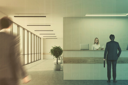 Modern office lobby with a white and wooden reception desk with business people passing by. 3d rendering mock up double exposure toned imageの写真素材