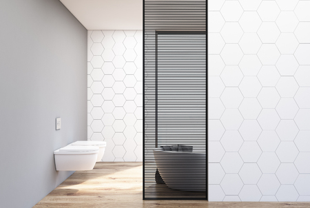 White hexagon tile bathroom interior with two toilets and a white bathtub behind a wooden decoration element. 3d rendering mock upの写真素材