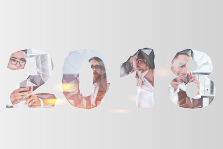 Diverse business team members at work. 2018 digits are in the foreground. A cityscape in the background. Toned image double exposure mock up 3d renderingの写真素材