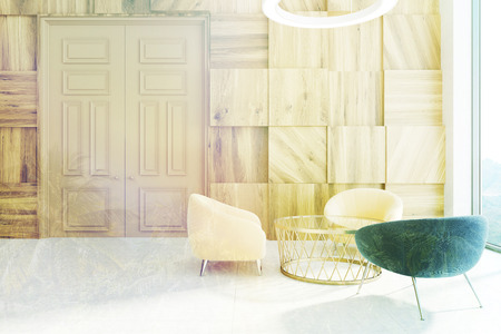 Wooden office waiting area with a large door, a concrete floor, a round coffee table with yellow and...
