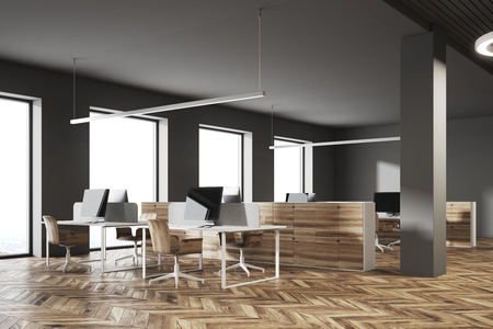 Dark wall office corner with wooden computer tables and large windows. Blank displays. 3d rendering mock upの写真素材