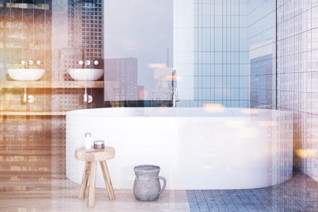 Modern bathroom interior with white and tiled walls, a tall window, a wooden floor, a double sink...
