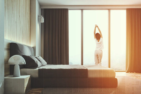 Wooden wall loft bedroom or a luxury hotel room with a wooden floor and walls, and a king size bed. A side view, a woman 3d rendering mock up toned image double exposureの写真素材