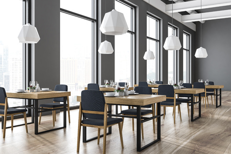 Gray modern bar interior with a wooden floor, large windows, square wooden tables. A poster. A side view. 3d rendering mock upの写真素材