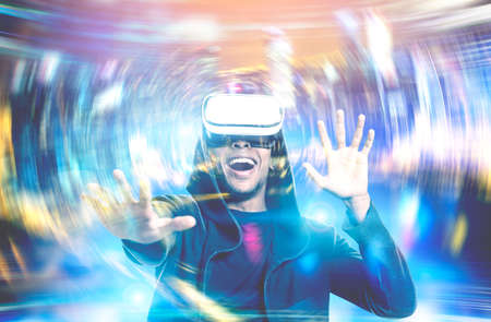 Happy young African American man wearing a hoodie and VR glasses. Concept of the future technology....