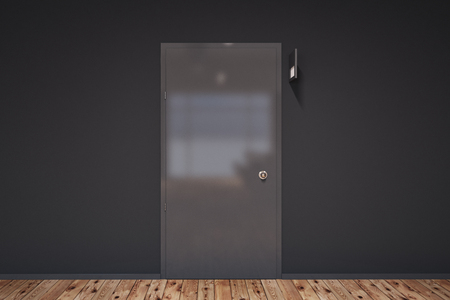 Closed black door with a table above it in an office or college corridor with a wooden floor. Choice and business concept. 3d rendering mock upの写真素材