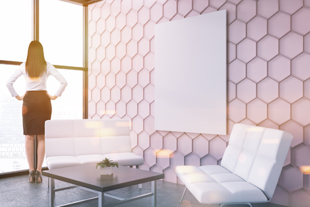Woman in a pink honeycomb wall pattern office lounge with loft windows, a coffee table, and two white sofas. A vertical poster. Side view. 3d rendering mock up toned imageの写真素材