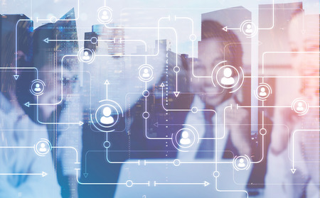 Members of a diverse business team sitting together at the table. A cityscape. A global network hologram in the foreground. Toned image double exposureの写真素材