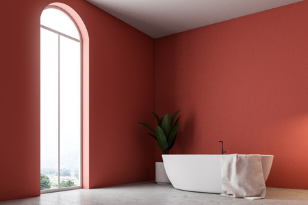 Minimalistic red bathroom interior with a white bathtub, a towel hanging on it, and a potted tree. A window 3d rendering mock upの写真素材