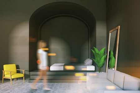 Interior of a cozy bedroom with a white sofa, a bed on the piedestal and a tall mirror standing near the wall. A woman 3d rendering mock up toned image double exposure blurredの写真素材