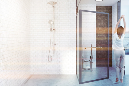 White brick bathroom interior with an open glass door, a sink and a shower. A concrete floor. A woman 3d rendering mock up toned image double exposureの写真素材