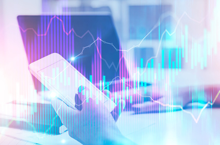 Businesswoman holding a smartphone and sitting at the table. Glowing Forex style graphs and bar...