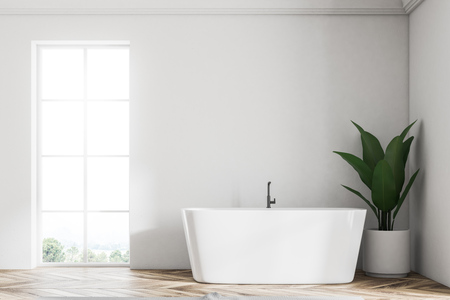White wall loft bathroom interior with a wooden floor. An angular white tub is standing near the window. A potted plant is next to it. A close up. 3d rendering mock upの写真素材