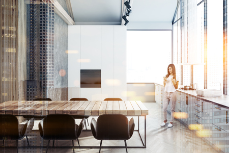 Loft kitchen interior with white, concrete and wooden walls, white countertops with built in appliances and a wooden table with chairs. Woman. 3d rendering mock up toned image double exposureの写真素材
