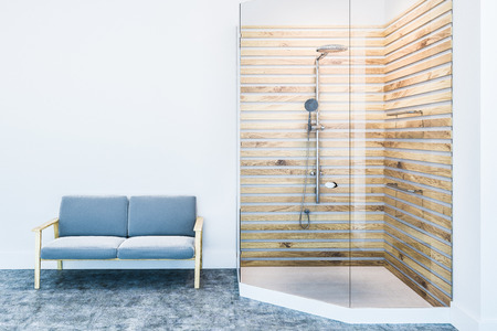 Stylish bathroom interior with white walls, a concrete floor, a white and wooden shower stall and a gray couch standing near it. 3d rendering mock upの写真素材