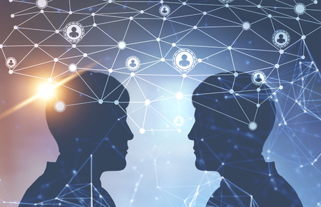 Silhouettes of two men facing each other against a blurred blue background. A glowing network hologram in the foreground. Toned image double exposureの写真素材