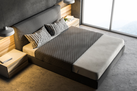 Top view of a modern bedroom with gray walls, a concrete floor, a double bed and two bedside tables...