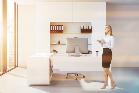 Businesswoman in manager office with peach walls, concrete floor, panoramic windows, and a large computer desk. 3d rendering toned imageの写真素材