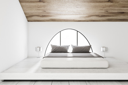 Interior of an attic bedroom with a master bed, wooden ceiling, white wooden floor and white walls. A small arched window. 3d rendering mock upの写真素材